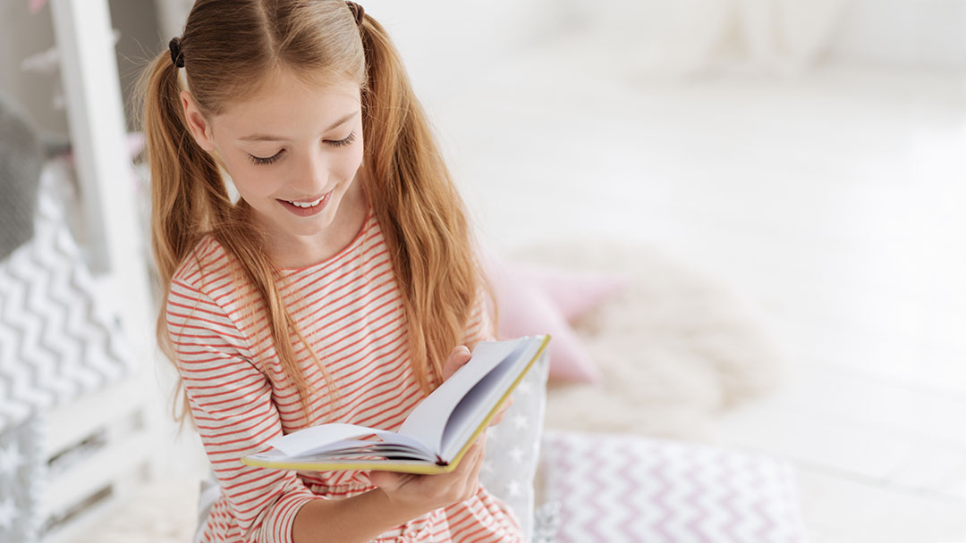 Girl reading Curious George